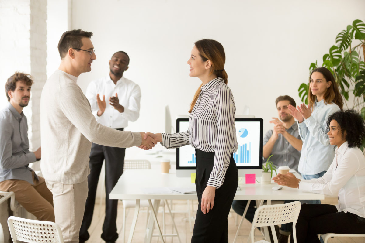 Sales manager offering public praise in front of sales team