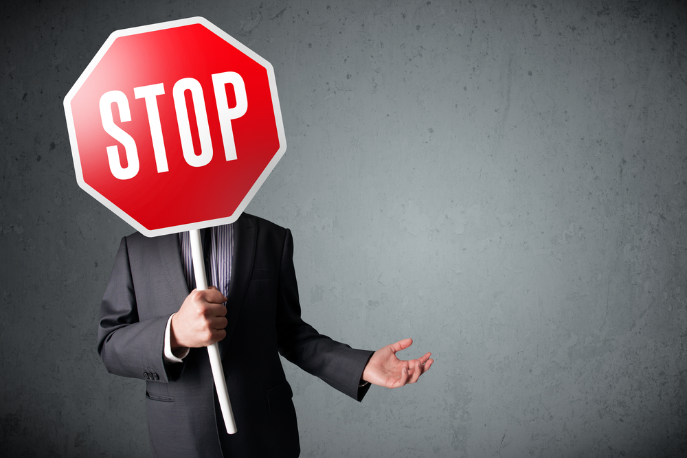 Businessman holding up Stop Sign