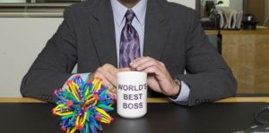 Businessman sitting with World's best Boss mug to represent managing up